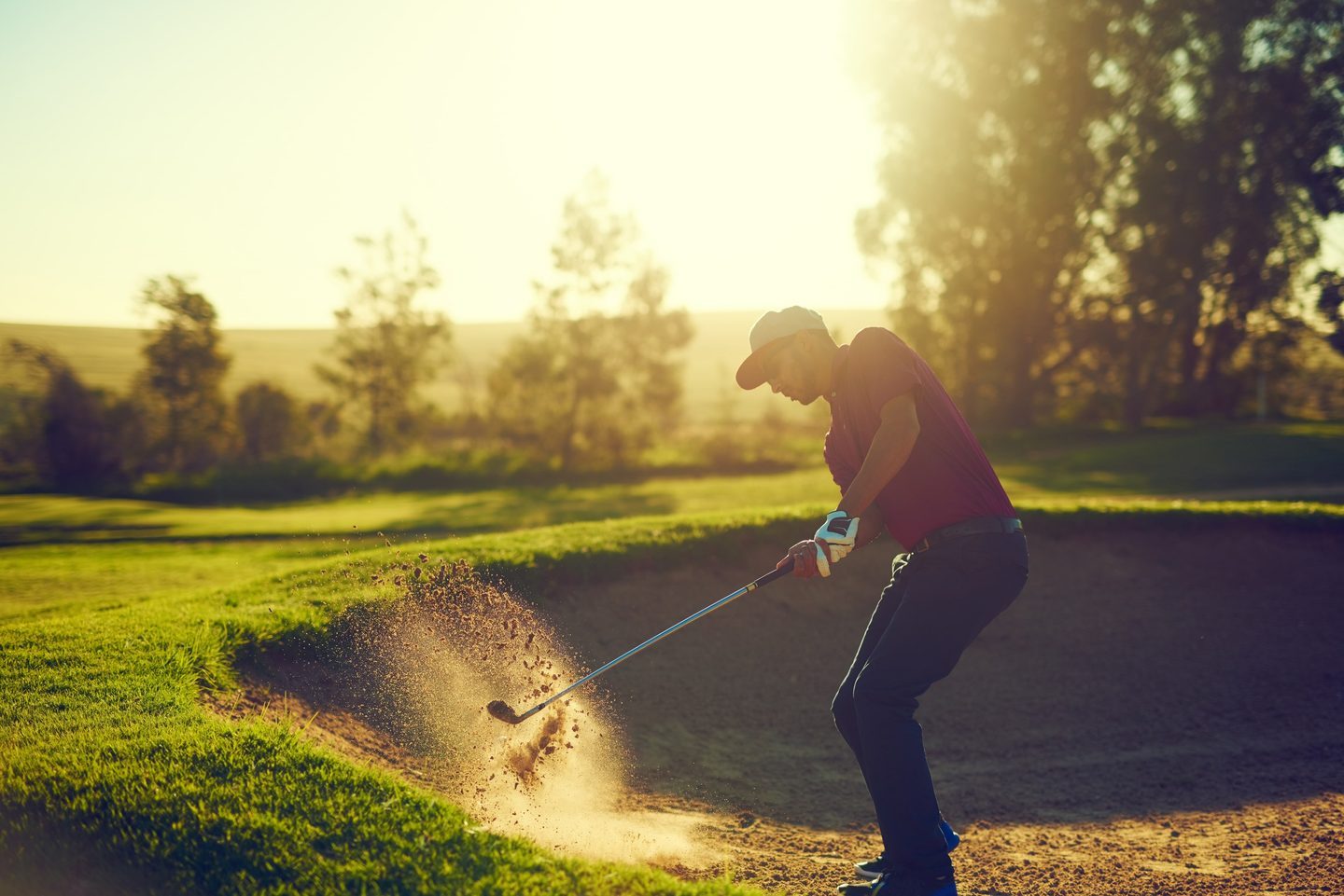 Golfer hitting out of a bunker
