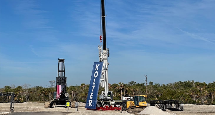 Crane with Kolter Flag at The Island at West Bay Club Groundbreaking Ceremony