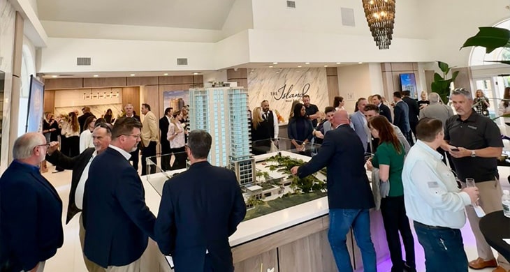 People gathered around The Island at West Bay Club Topo Table