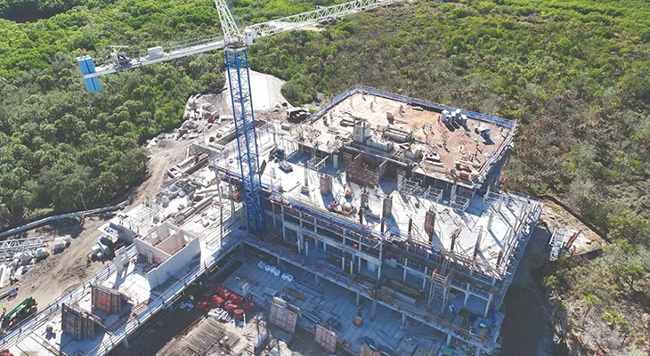 Aerial view of a multi-story building under construction with crane and workers