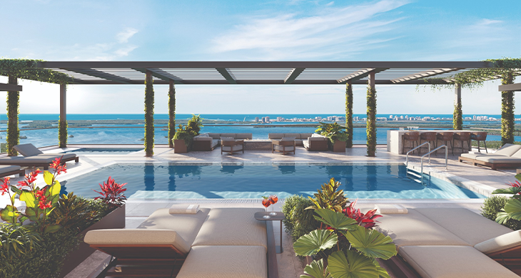 Tall residential tower set within a coastal landscape.