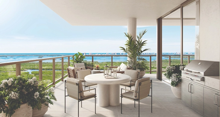 Residential balcony with round dining table, chairs, grill and water view