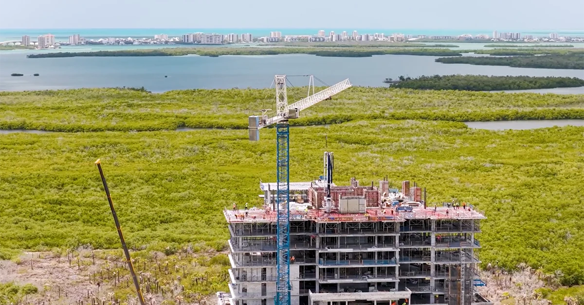 Luxury condominium tower under construction near coastal preserves in Estero, Florida.